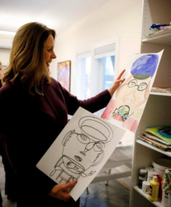 Executive Director Margaret Keller, admiring an artist’s artwork.
